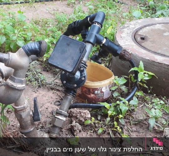 ברזים וצינורות מחוברים עם סרט שחור בגינה